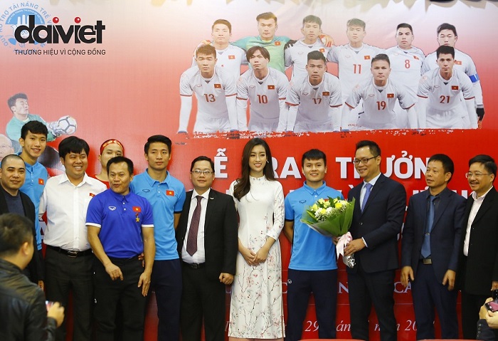Ông Ngô Xuân Mạnh (bên phải hậu vệ Đoàn Văn Hậu), hoa hậu Đỗ Mỹ Linh chụp hình lưu niệm cùng các cầu thủ U23 Việt Nam